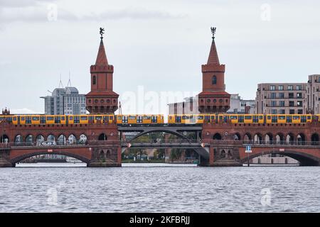 Berlin, Germany - Sept 2022: Beautiful view of famous Oberbaum Bridge crossing the Spree river with yellow train on a cloudy day Stock Photo