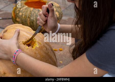 Carved Halloween pumpkin, jack lantern, with carving tools. Spooky laughing, scary head. Stock Photo