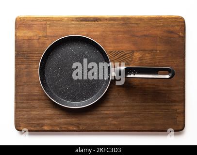 Empty pan on wood board. Empty marble coated iron pot Stock Photo