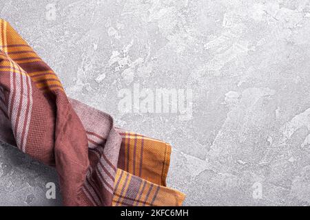 Top view of brown folded kitchen towel or serviette on grey concrete background Stock Photo