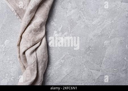 Top view of folded kitchen towel or serviette on grey concrete background Stock Photo