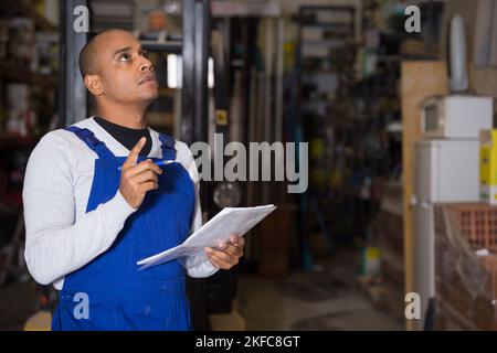 Confident worker taking inventory in building materials store Stock Photo