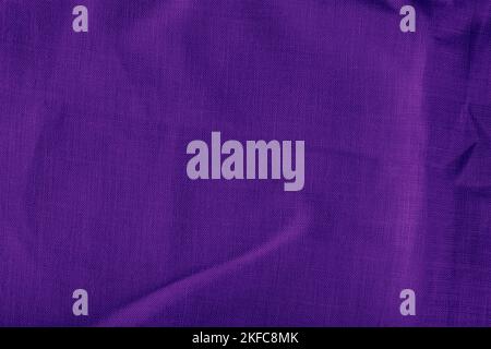 Purple linen fabric. Texture of crumpled linen fabric in folds close-up. Stock Photo