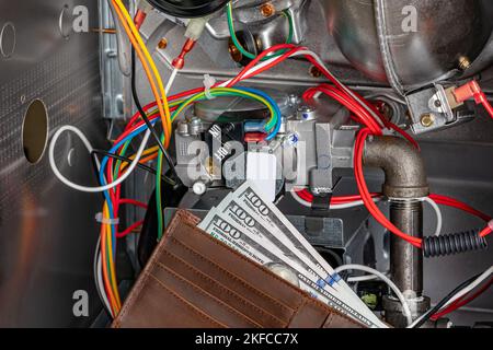 Furnace gas valve and wallet with cash money. HVAC maintenance, repair, service and installation concept. Stock Photo