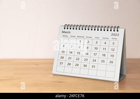 March 2023 paper calendar on the wooden table - month page Stock Photo