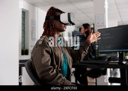 It programmer working with virtual reality headset to develop server app in it big data office, using source code. Checking programming language on cloud computing database, web developer. Stock Photo