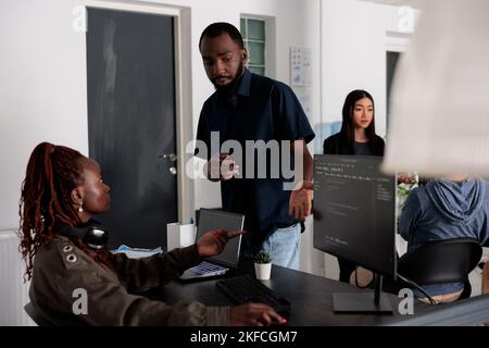 Ai cloud programers talking about html script in looking at code on computer, working on server interface development. Web developers doing teamwork to plan programming software language. Stock Photo