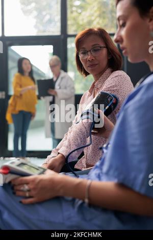Specialist measuring hypertension and hypotension on asian woman, using ...