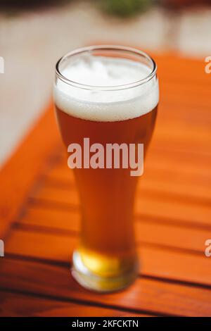 Color image of a glass of fresh light beer on a wooden table. Stock Photo