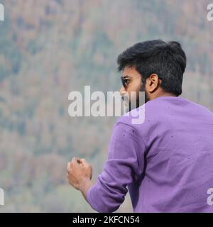 A handsome man in a purple shirt and sunglasses Stock Photo