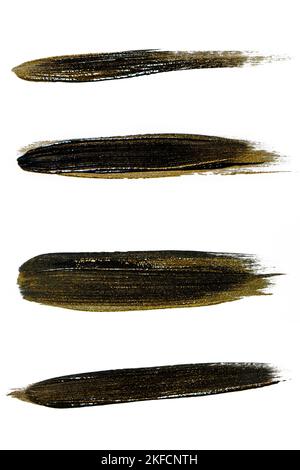 A set of black paint strokes with gold on a white background. Stock Photo