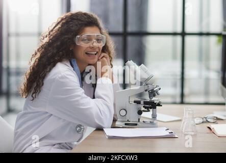 Young woman in biological laboratory. Attractive young female scientis. Scientist using a microscope in a laboratory Stock Photo