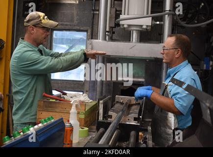 A Crane Army explosive leader explains to an engineer technician the problem with a piece of equipment in the white phosphorous plant. Cross-training is an important aspect while working as a team to solve problems at CAAA. Joint Munitions Command,army materiel command,crane army ammunition activity,cross training,demilitarization, Stock Photo