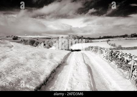 Black and white infrared images of snow laden country track in winter Peak District National Park Derbyshire England United Kingdom Stock Photo