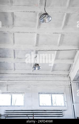 LED lamps on white ceiling in industrial building. Lamps in construction work shop at factory. Stock Photo