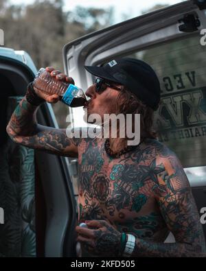A vegan ultra Tattoo Runner, Mat Grills during ultramarathon standing with a bottle in hand Stock Photo