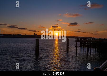 A bright golden sunset sky over the river Mersey in Liverpool Stock Photo