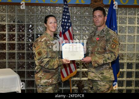 ROBINS AIR FORCE BASE, Ga. – Col. Lindsay Droz, 78th Air Base Wing commander, left, presents the citation for the Bronze Star Medal to Master Sgt. Mathue B. Snow, 78th Security Forces Squadron, at Robins Air Force Base, Georgia, Sept. 9, 2022. Snow was decorated for actions during the Jan. 5th, 2020, complex attack on Manda Bay, Kenya, where one American Soldier and two Department of Defense civilian contractors lost their lives, and six U.S. aircraft and one Kenyan aircraft were destroyed. Stock Photo