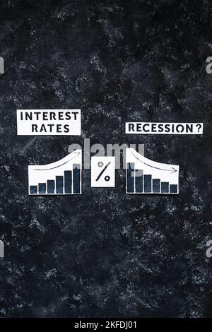 Interest Rates and Recession text with percentage symbol and charts showing cost of loans going up  and economic growth going down, concept of post pa Stock Photo