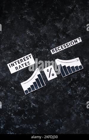 Interest Rates and Recession text with percentage symbol and charts showing cost of loans going up  and economic growth going down, concept of post pa Stock Photo