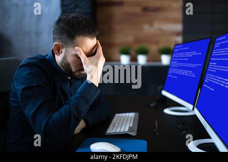 Worried Man At Computer With System Failure Screen At The Workplace Stock Photo