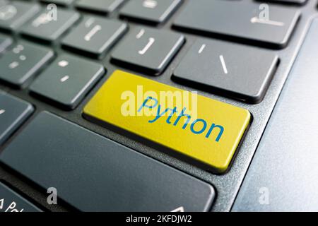 button with the python on the yellow keyboard of a modern laptop. Stock Photo