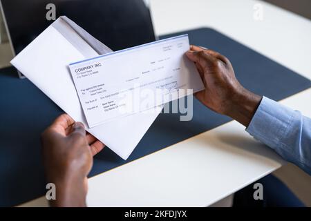 American African Holding Paycheck Or Payroll Check Stock Photo