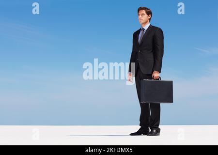 Thoughtful young business man holding a briefcase. Full Length portrait of a thoughtful young business man holding a briefcase. Stock Photo