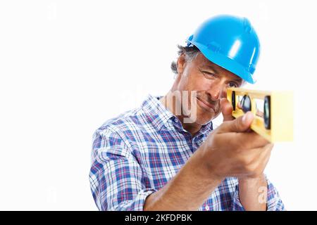 Architect using spirit-level. Portrait of mature architect using spirit-level over white background. Stock Photo