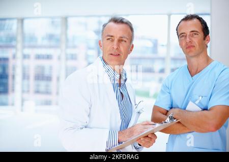 Doctor and resident distracted. Health care professionals looking at something off camera. Stock Photo