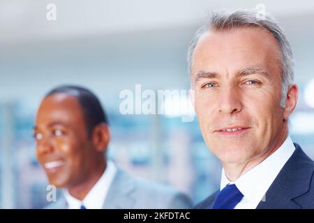 Happy senior executive with partner in background. Focus on senior executive with partner in background. Stock Photo