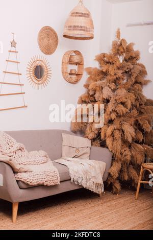 Stylish modern sofa in the home interior. Christmas tree made of dried flowers Stock Photo