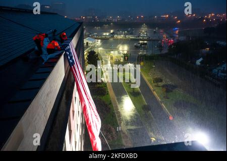 Pentagon officials unfurled an American flag over the side of the Pentagon in the rain during an observance ceremony at the National 9/11 Pentagon Memorial to honor the 184 lives lost in the 2001 terrorist attack on the Pentagon, Washington, D.C., Sept. 11, 2022. Stock Photo