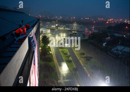 Pentagon officials unfurled an American flag over the side of the Pentagon in the rain during an observance ceremony at the National 9/11 Pentagon Memorial to honor the 184 lives lost in the 2001 terrorist attack on the Pentagon, Washington, D.C., Sept. 11, 2022. Stock Photo