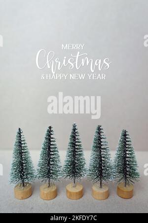 Merry Christmas and happy new year quote with miniature christmas trees. Stock Photo