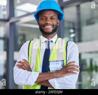 Portrait, construction and engineer man or construction worker with arms crossed in industrial startup office. Architecture, builder and industry with Stock Photo