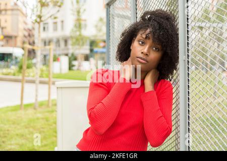 pensive african american young woman in public city park Stock Photo