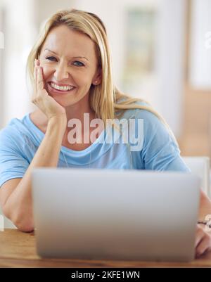 Chatting with someone special. Portrait of a mature woman using a laptop at home. Stock Photo