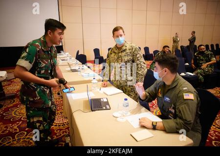 Maj. Eko Prakoso, TNI, provides direction to US Navy, Lt. Cmdr Roger Long, and Lt. j.g COLBY Mcliverty as they take their place on the planning group KOGABWILHAN 3, September 12, 2022, Jakarta Indonesia. Gema Bhakti 22 is a USINDOPACOM Joint Exercise Program event, utilizing US Joint forces partnering with TNI Armed Forces working together to increase interoperability and enhance regional stability and security through bilateral and multilateral partnerships. (US Air Force Photo by Master Sgt. Andrew Jackson) Stock Photo