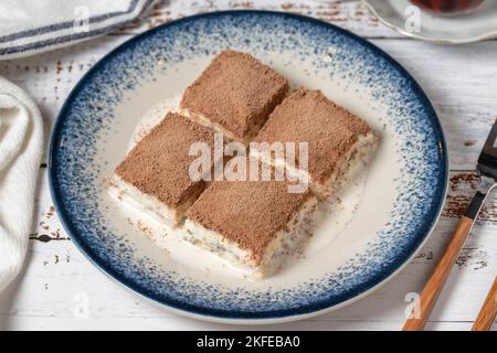 Cold baklava on a white wooden background. Baklava with milk and pistachio. Mediterranean cuisine delicacies. close up Stock Photo