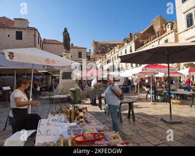 Walking around the streets of Debrovnik in Croatia. Old town market with umbrellas providing shade for the stall holders Stock Photo