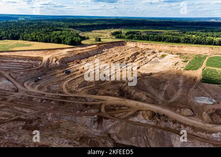 View from a high altitude of a sand pit growing due to the fields Stock Photo