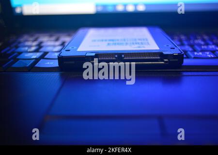 SSD drives are very popular these days, SSDs are placed on laptops (this photo was intended to look dark and use blue light). Stock Photo