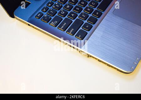 side view left side of laptop on a white background and using yellow-orange light Stock Photo