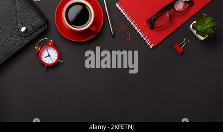 black background red coffee cup note pad alarm clock flower diary scores keyboard Stock Photo