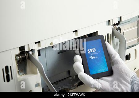 2.5 inch ssd hard drive that technician is installing in computer Stock Photo