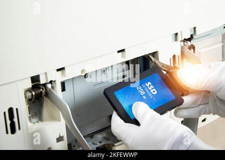 2.5 inch ssd hard drive that technician is installing in computer Stock Photo