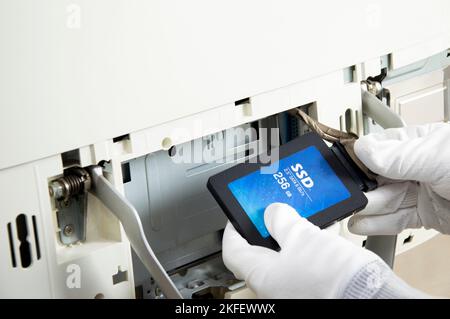 2.5 inch ssd hard drive that technician is installing in computer Stock Photo