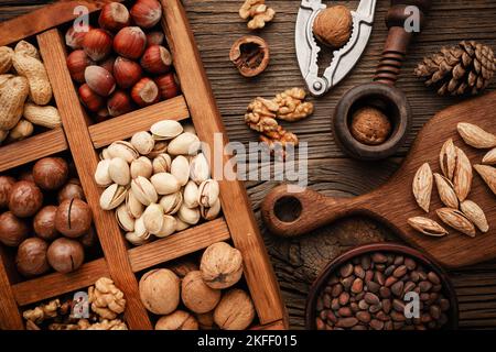 Various nuts selection: peanuts, hazelnuts, chestnuts, walnuts, pistachio and pecans in wooden box. Top view with space for your text Stock Photo