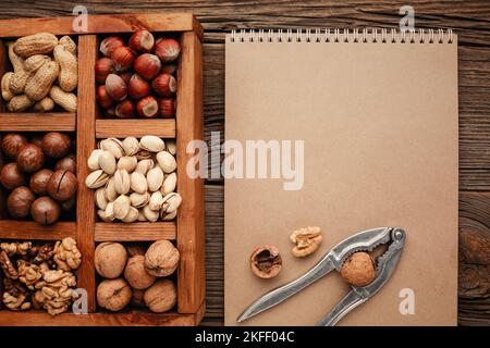 Various nuts selection: peanuts, hazelnuts, chestnuts, walnuts, pistachio and pecans in wooden box. Top view with space for your text Stock Photo